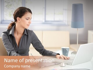 A Woman Sitting At A Desk Using A Laptop Computer PowerPoint Template