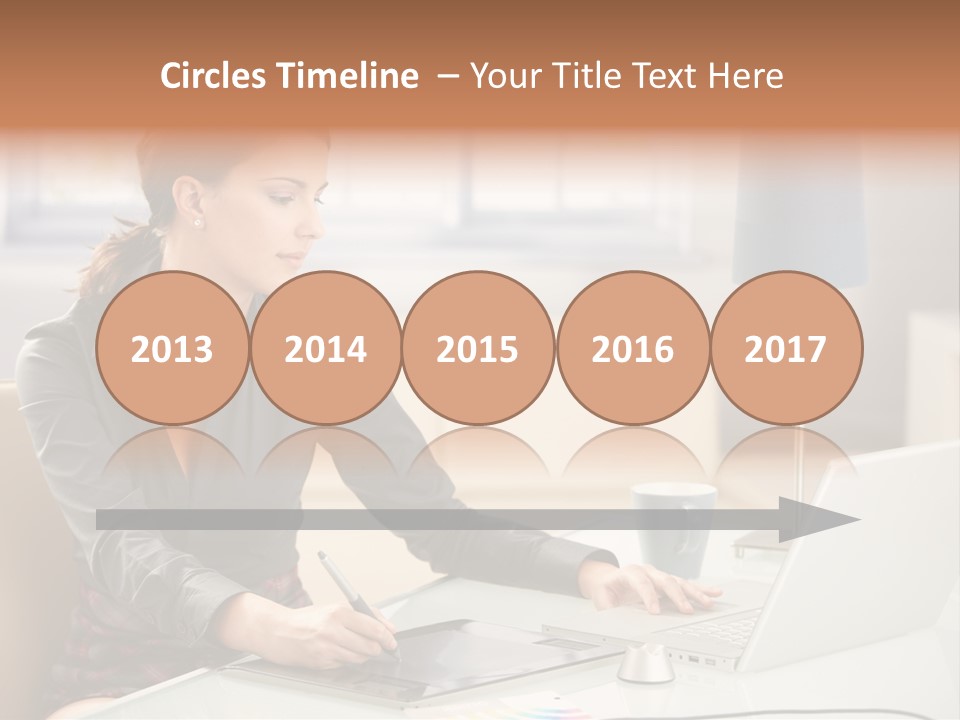 A Woman Sitting At A Desk Using A Laptop Computer PowerPoint Template