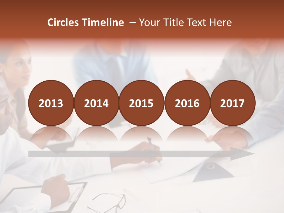 A Group Of People Sitting Around A Table PowerPoint Template