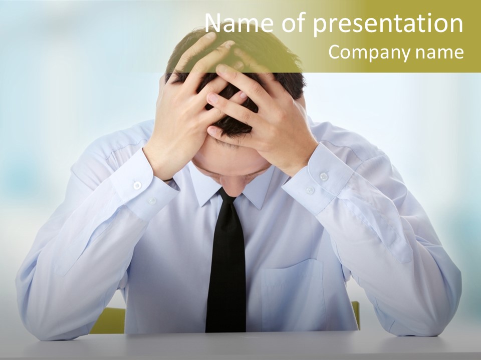 A Man Sitting At A Desk With His Hands On His Head PowerPoint Template