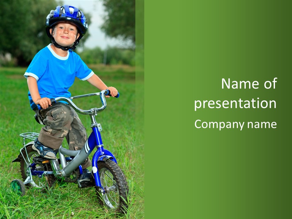 A Young Boy Is Riding A Bike In The Grass PowerPoint Template