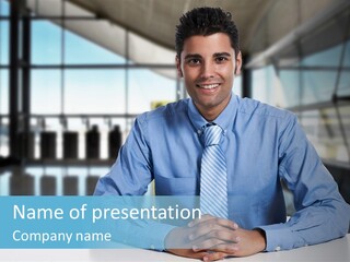 A Man In A Blue Shirt And Tie Sitting At A Table PowerPoint Template