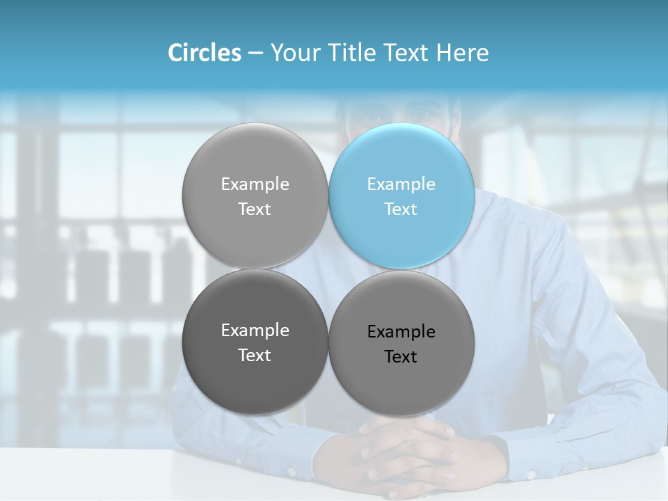 A Man In A Blue Shirt And Tie Sitting At A Table PowerPoint Template