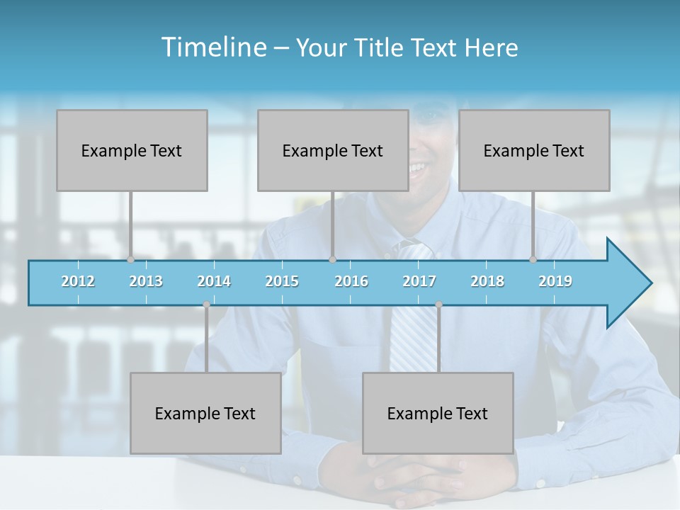 A Man In A Blue Shirt And Tie Sitting At A Table PowerPoint Template
