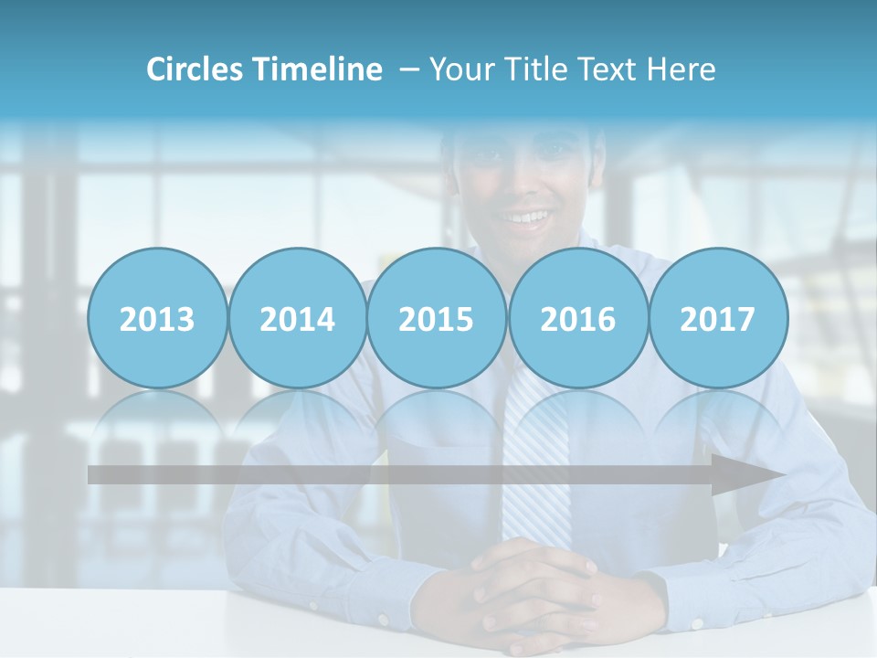 A Man In A Blue Shirt And Tie Sitting At A Table PowerPoint Template