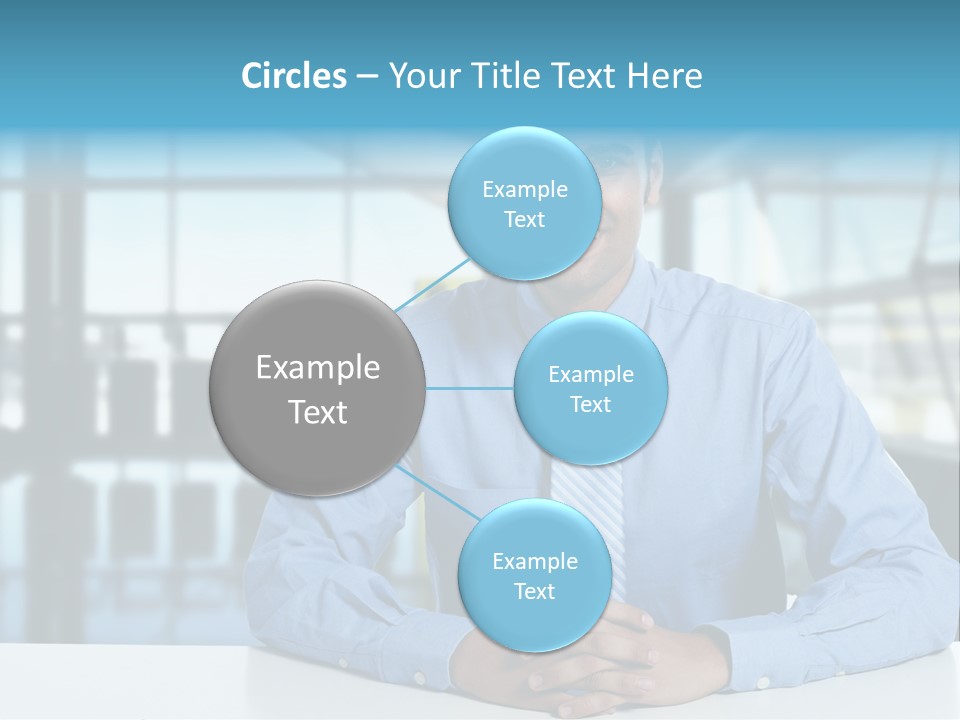 A Man In A Blue Shirt And Tie Sitting At A Table PowerPoint Template