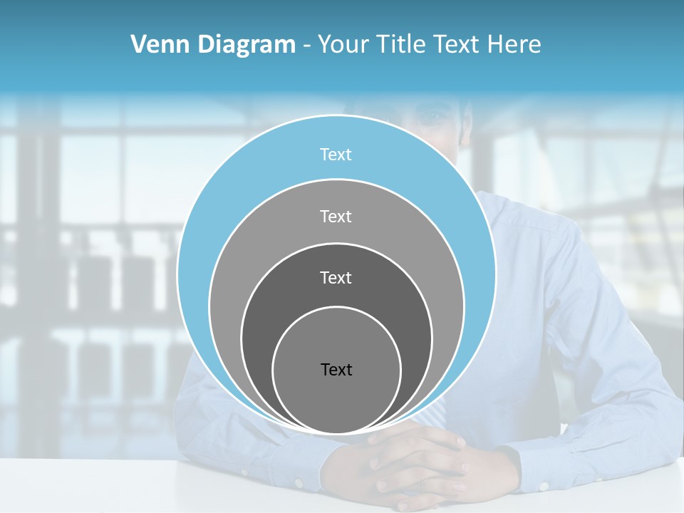A Man In A Blue Shirt And Tie Sitting At A Table PowerPoint Template