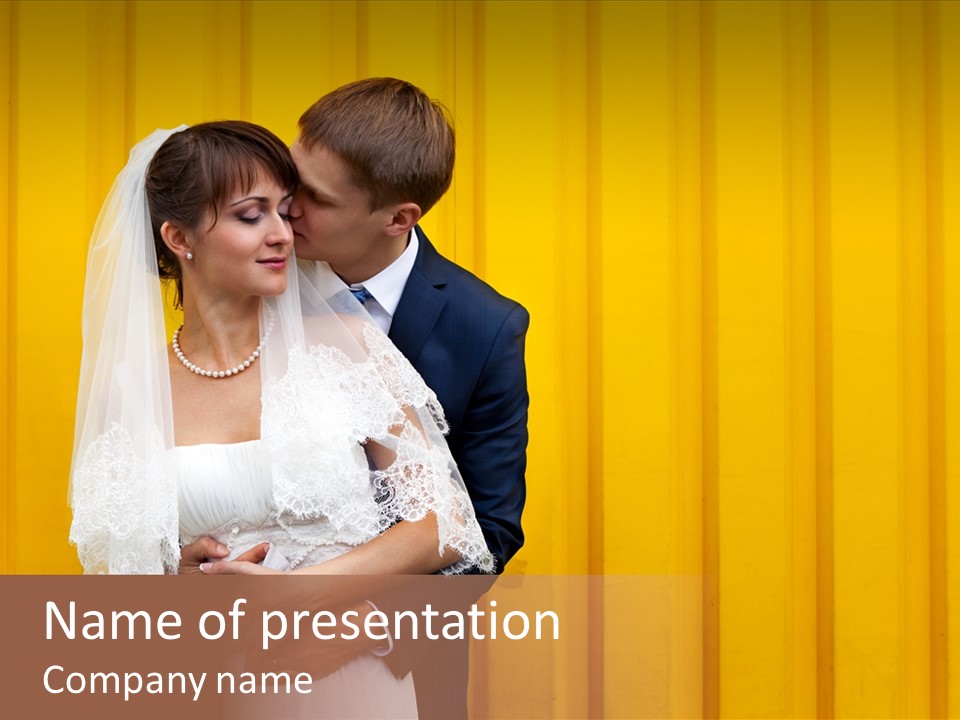 A Bride And Groom Kissing In Front Of A Yellow Wall PowerPoint Template