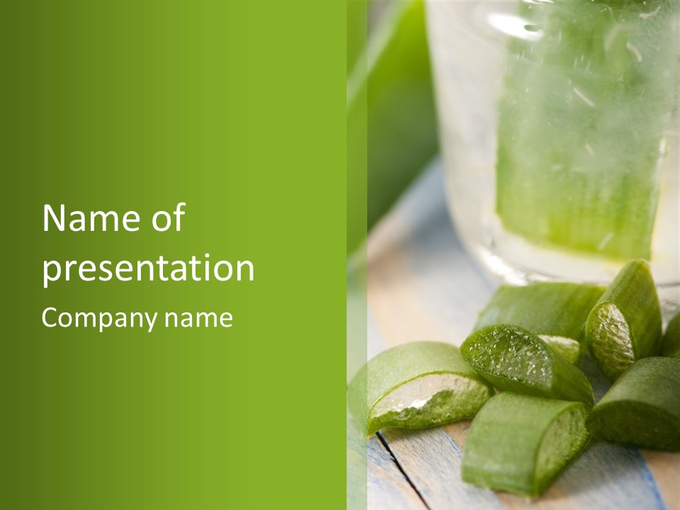 A Glass Filled With Green Liquid Next To Sliced Cucumbers PowerPoint Template