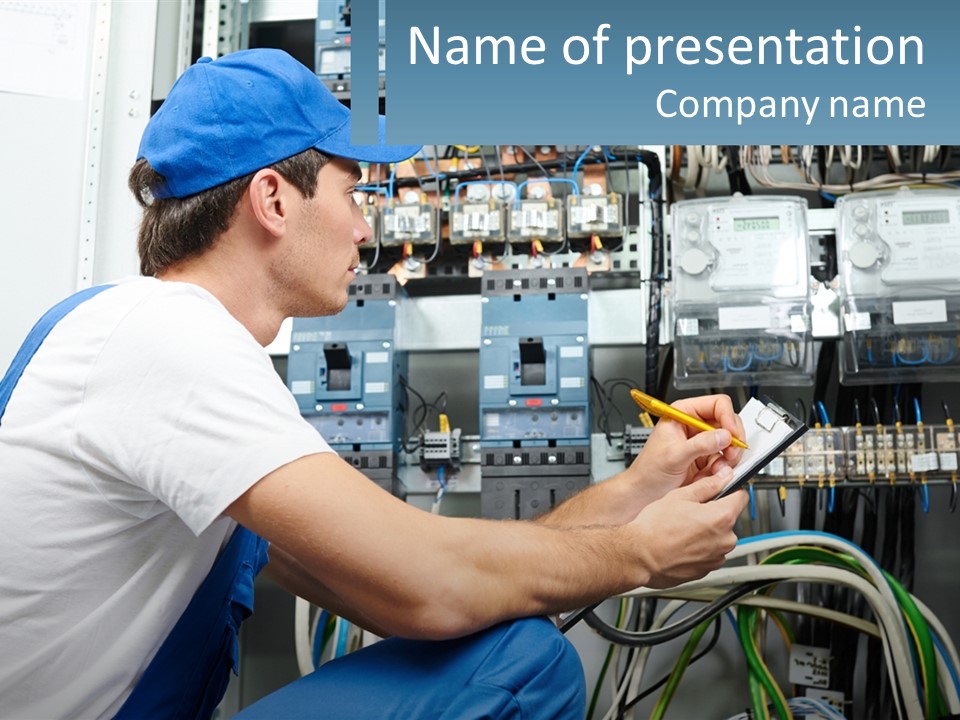 A Man In Overalls And A Blue Cap Is Working On An Electrical Panel PowerPoint Template