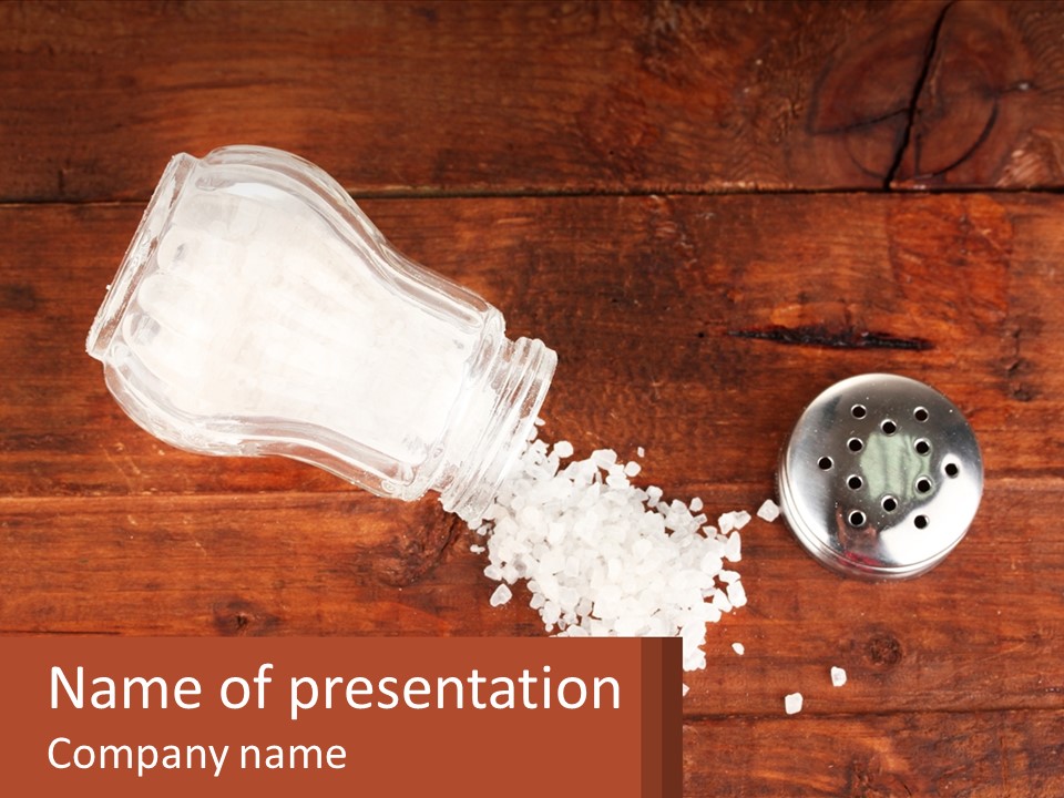 A Salt Shaker And A Scoop Of Salt On A Wooden Table PowerPoint Template