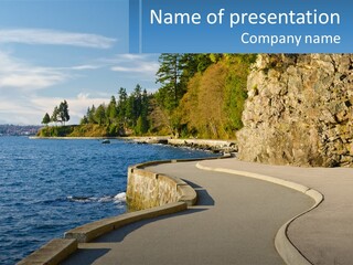 A Paved Road Next To A Body Of Water PowerPoint Template