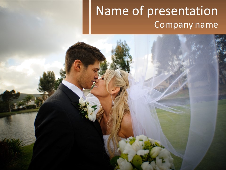 A Bride And Groom Kissing In Front Of A Lake PowerPoint Template