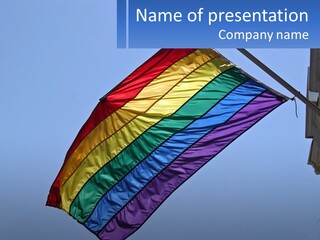 A Rainbow Colored Kite Flying In The Sky PowerPoint Template