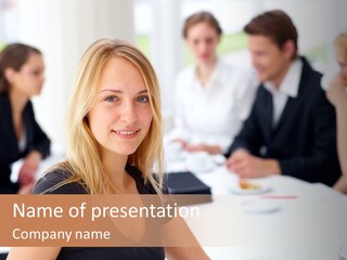 A Woman Sitting At A Table In Front Of A Group Of People PowerPoint Template