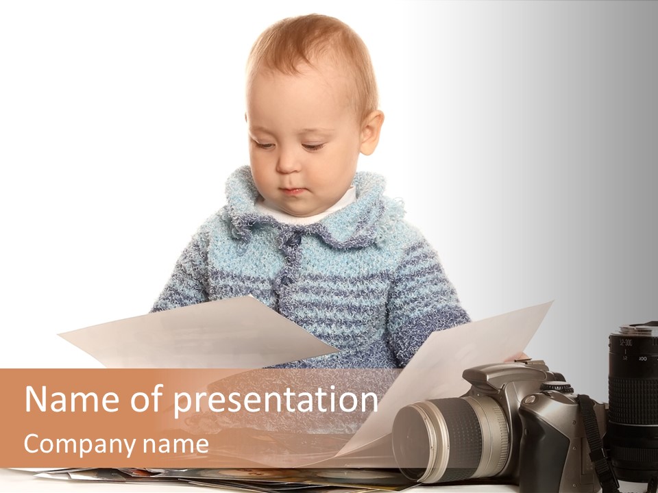 A Baby Reading A Book Next To A Camera PowerPoint Template