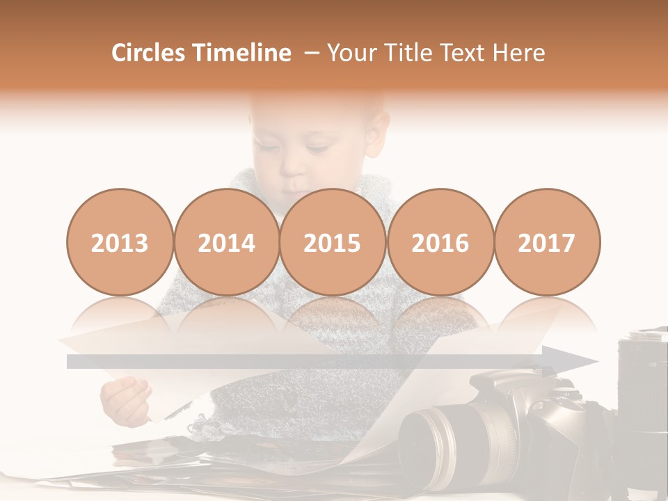 A Baby Reading A Book Next To A Camera PowerPoint Template