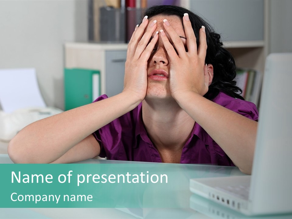 A Woman Covering Her Eyes While Sitting At A Desk PowerPoint Template
