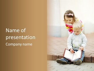 Two Children Sitting On The Ground Reading A Book PowerPoint Template