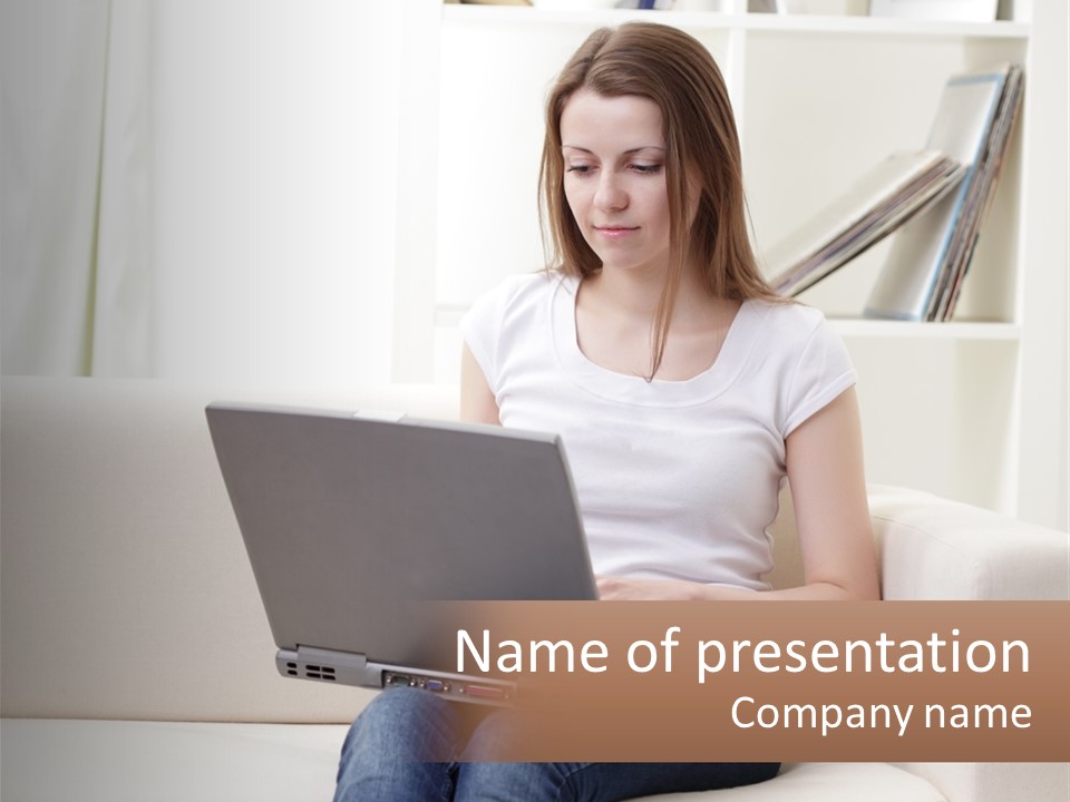 A Woman Sitting On A Couch Using A Laptop Computer PowerPoint Template