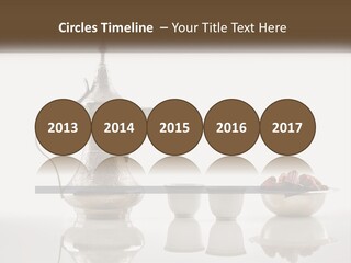 A Silver Tea Pot And Cups On A Table PowerPoint Template