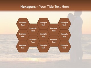 Two People Standing On A Beach At Sunset PowerPoint Template