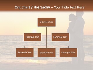 Two People Standing On A Beach At Sunset PowerPoint Template