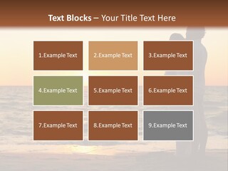 Two People Standing On A Beach At Sunset PowerPoint Template