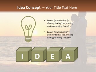 Two People Standing On A Beach At Sunset PowerPoint Template