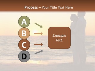 Two People Standing On A Beach At Sunset PowerPoint Template