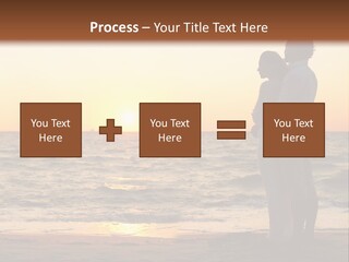 Two People Standing On A Beach At Sunset PowerPoint Template