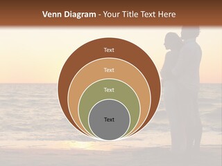 Two People Standing On A Beach At Sunset PowerPoint Template