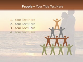 Two People Standing On A Beach At Sunset PowerPoint Template