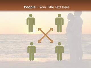 Two People Standing On A Beach At Sunset PowerPoint Template