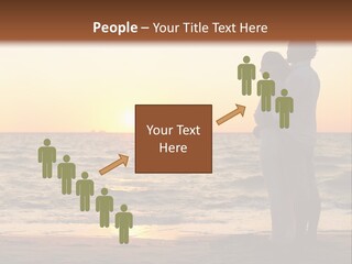 Two People Standing On A Beach At Sunset PowerPoint Template