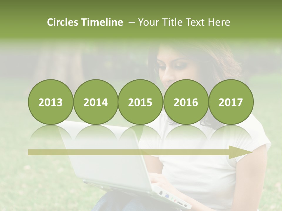 A Woman Sitting In The Grass Using A Laptop Computer PowerPoint Template