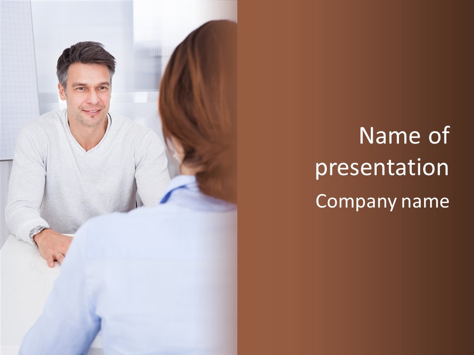 A Man Sitting At A Desk Talking To A Woman PowerPoint Template
