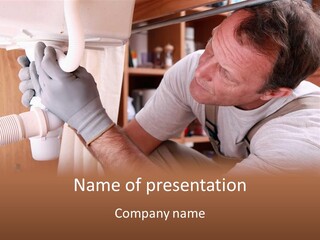 A Man Working On A Pipe In A Kitchen PowerPoint Template