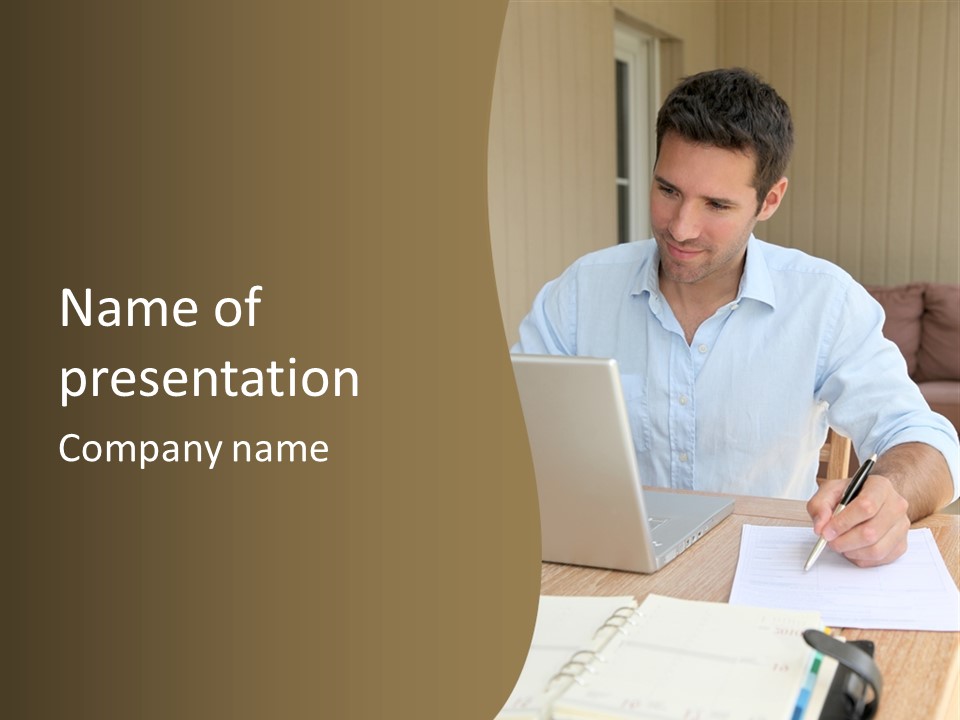 A Man Sitting At A Desk Writing On A Piece Of Paper PowerPoint Template