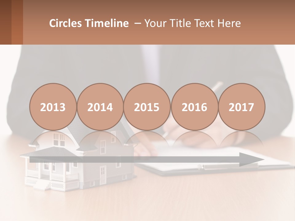 A Man In A Suit Writing On A Piece Of Paper Next To A Model House PowerPoint Template