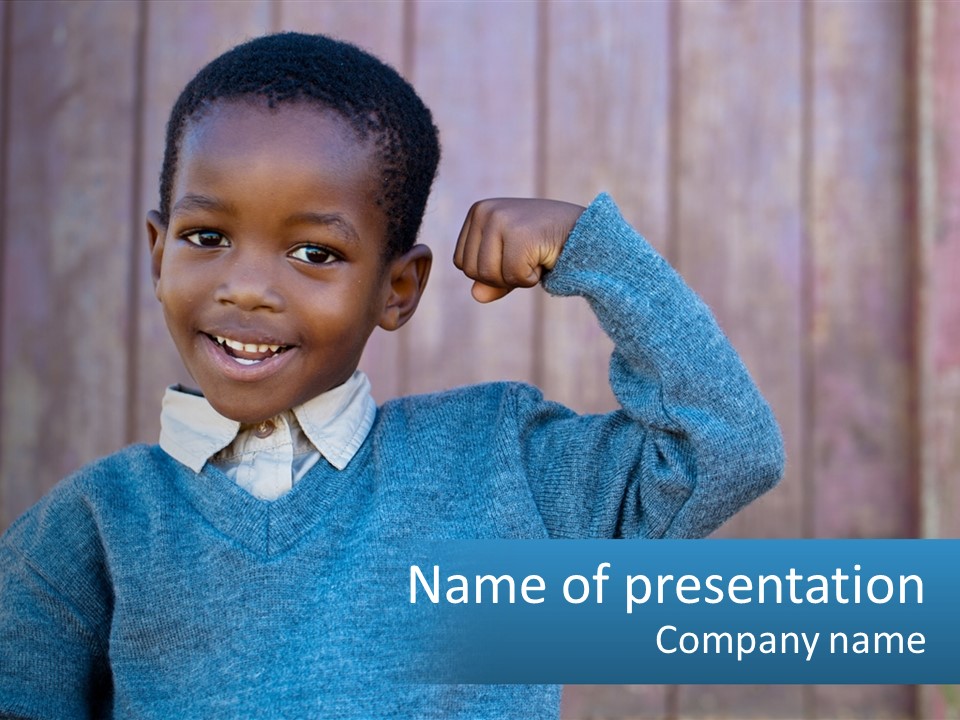 A Young Boy Flexing His Muscles In Front Of A Wooden Fence PowerPoint Template