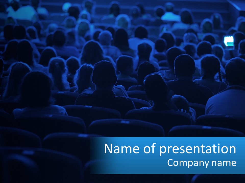 A Crowd Of People In A Theater Watching A Presentation PowerPoint Template
