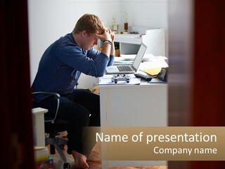 A Man Sitting At A Desk In Front Of A Laptop Computer PowerPoint Template