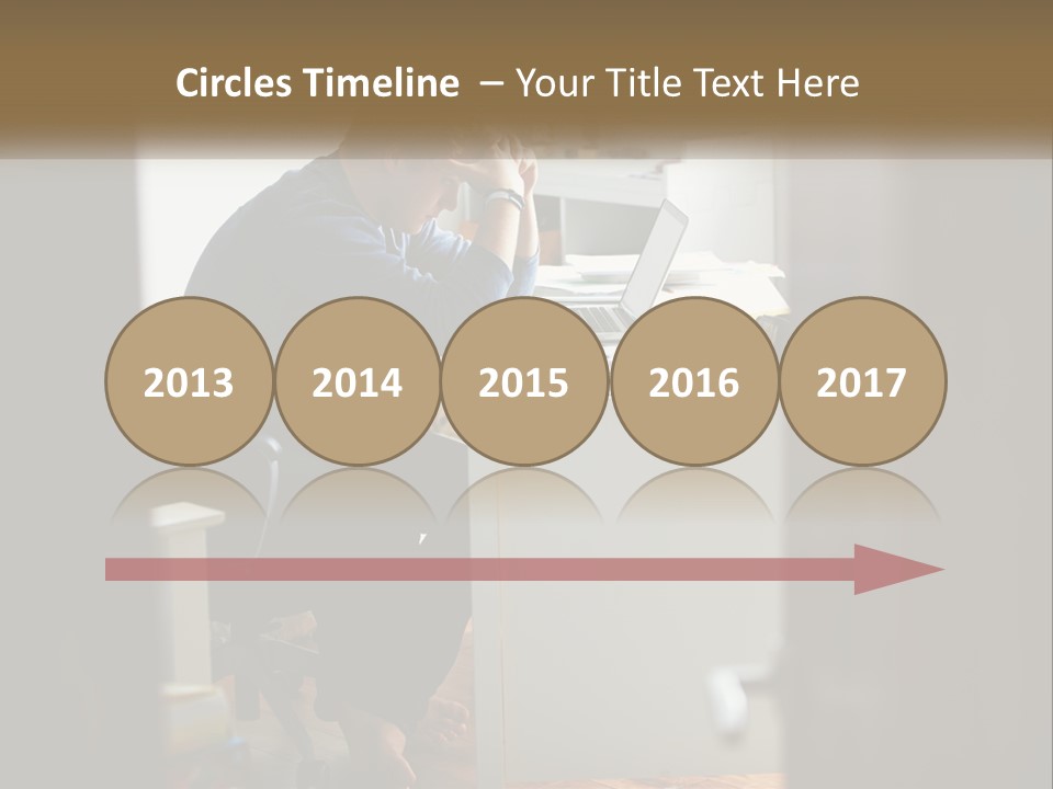 A Man Sitting At A Desk In Front Of A Laptop Computer PowerPoint Template