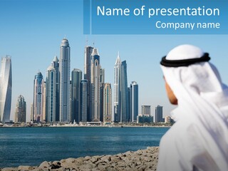 A Man Standing In Front Of A Body Of Water With A City In The Background PowerPoint Template
