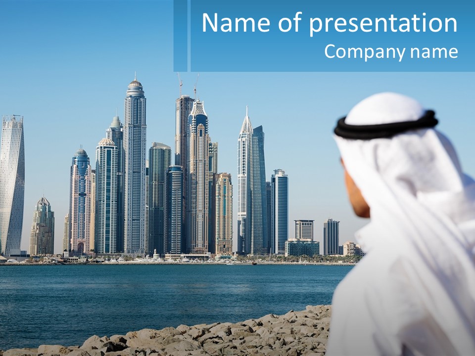 A Man Standing In Front Of A Body Of Water With A City In The Background PowerPoint Template