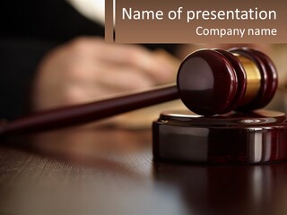A Wooden Judge's Gavel Sitting On Top Of A Wooden Table PowerPoint Template