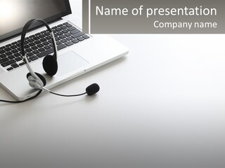 A Laptop With A Headset On Top Of It PowerPoint Template