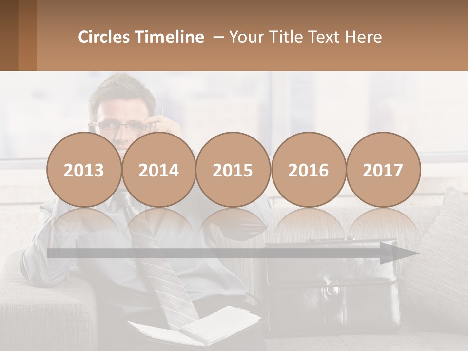 A Man Sitting On A Couch Talking On A Cell Phone PowerPoint Template