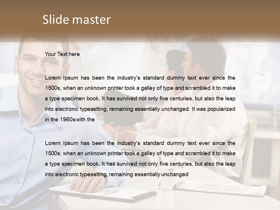 A Man Sitting At A Desk In Front Of A Group Of People PowerPoint Template